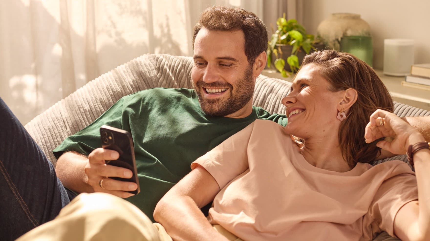 Kanepede oturmuş telefonuna bakan çift