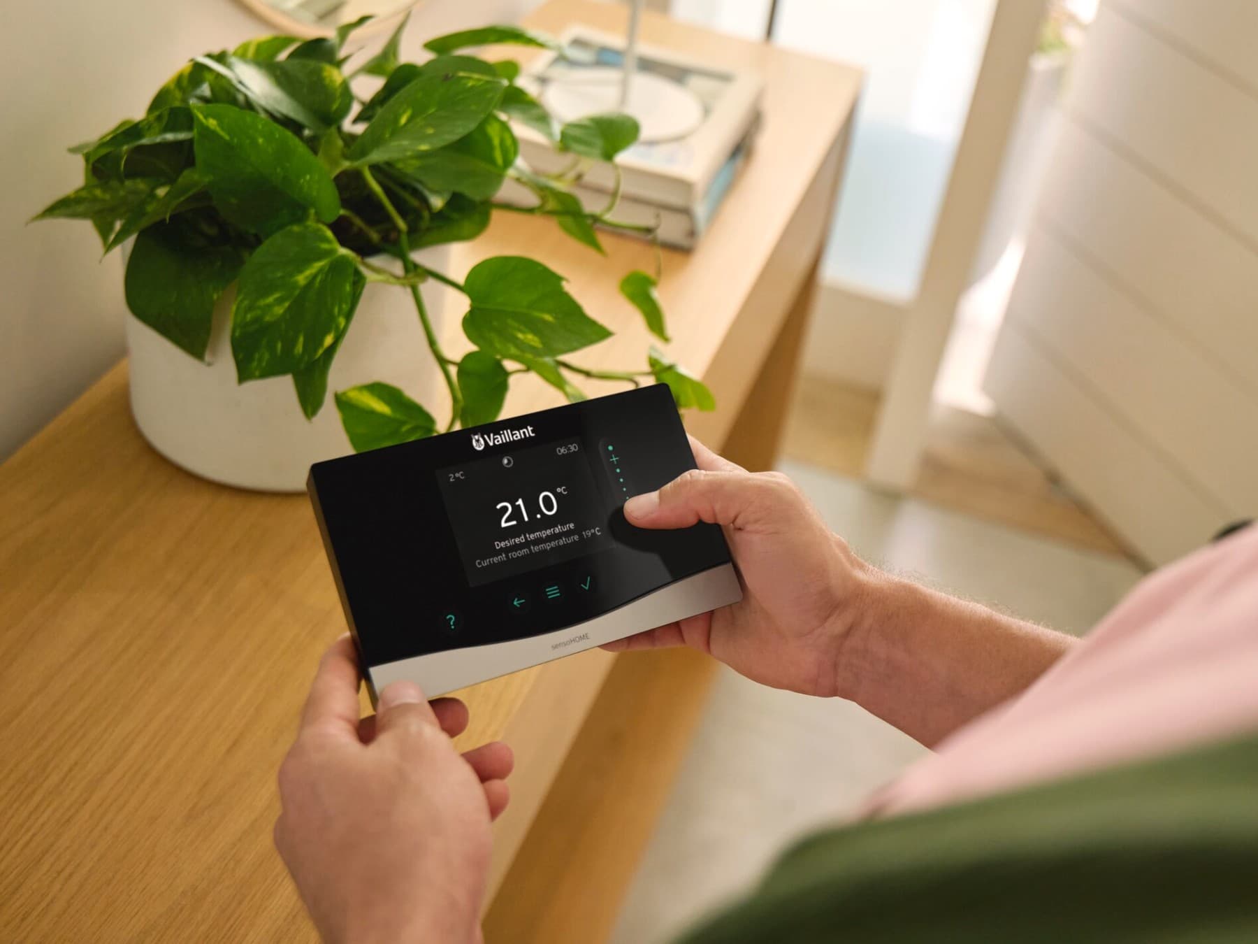 Elinde sensoCOMFORT sistem kontrol ünitesini tutan adam