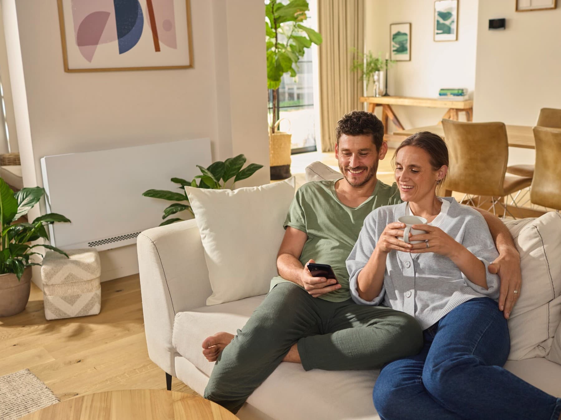 Kanepede oturmuş akıllı telefona bakan çift