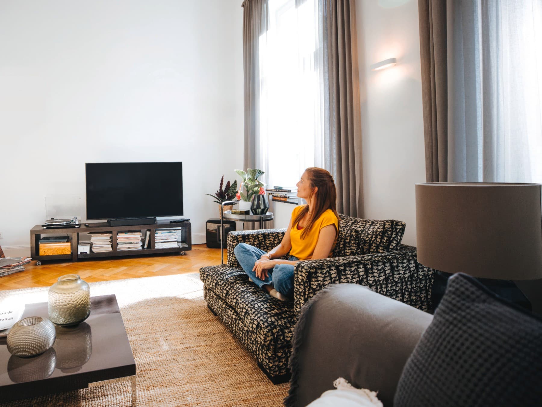Bir apartman dairesinde kanepede oturan kadın