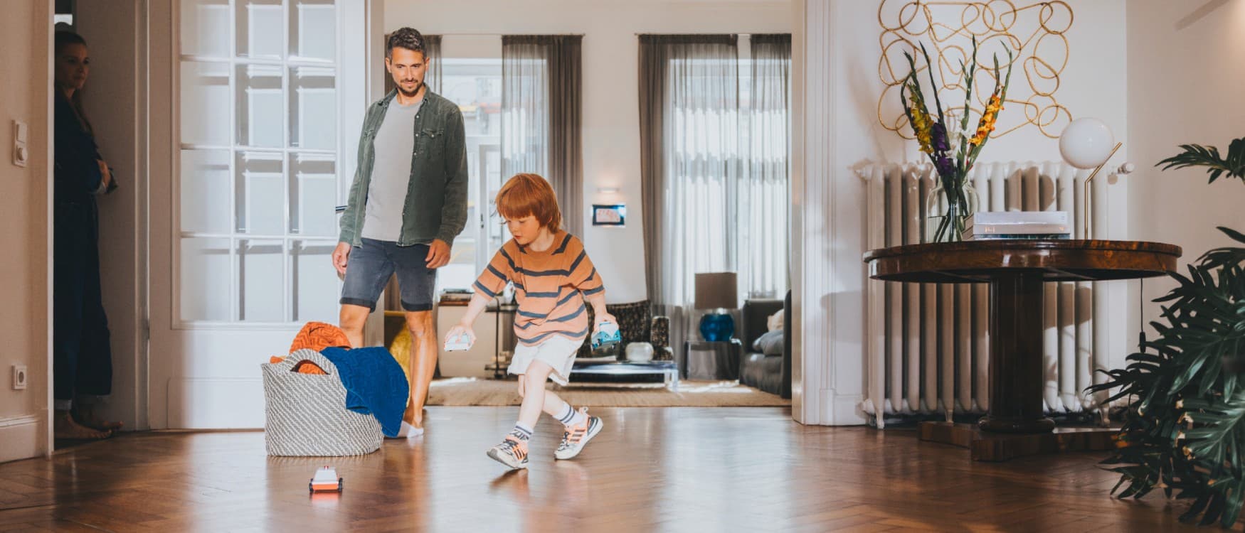 Baba, oğlunun oturma odasında oynadığını izliyor
