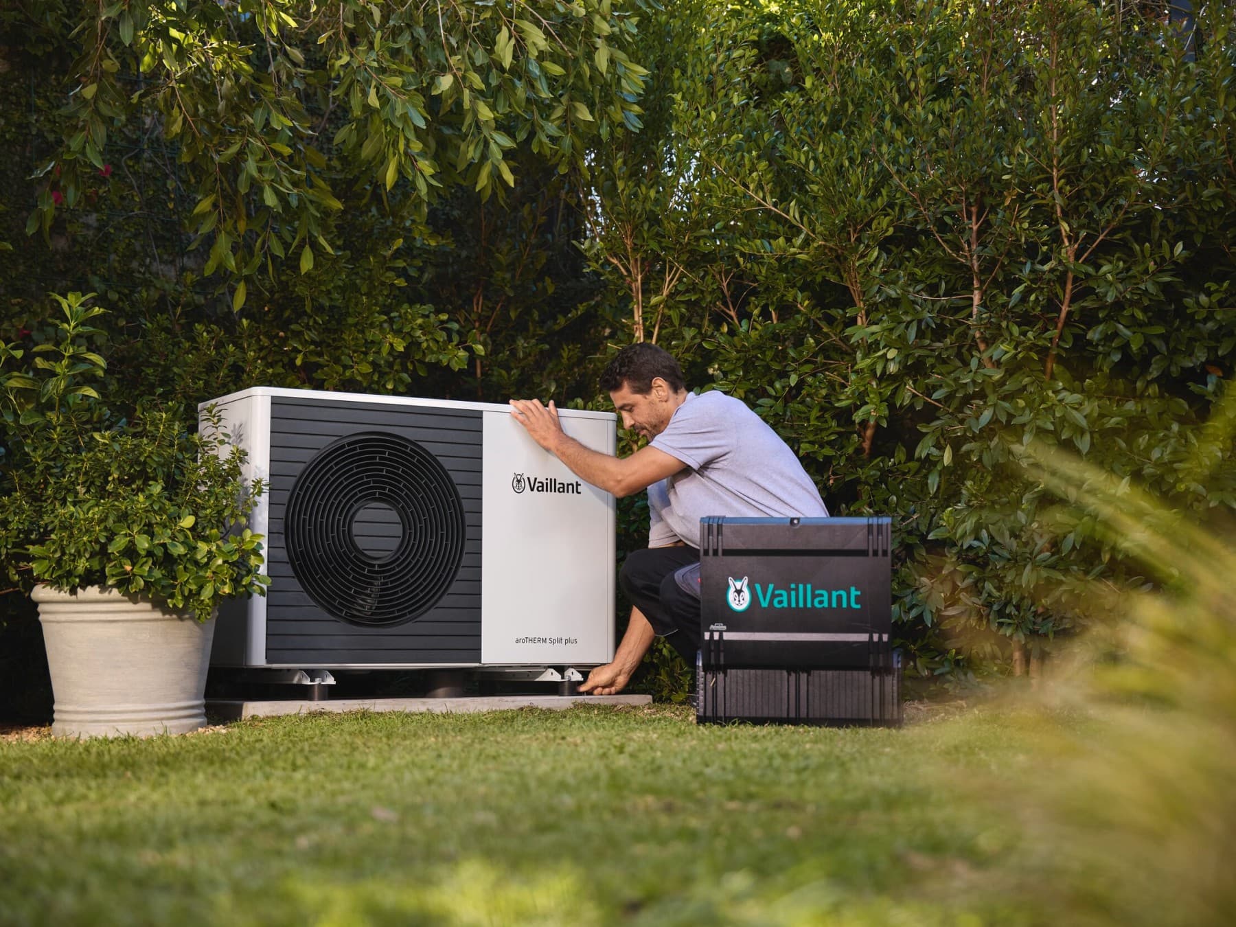 Bahçede bir vaillant ısı pompası üzerinde çalışan bir montajcı