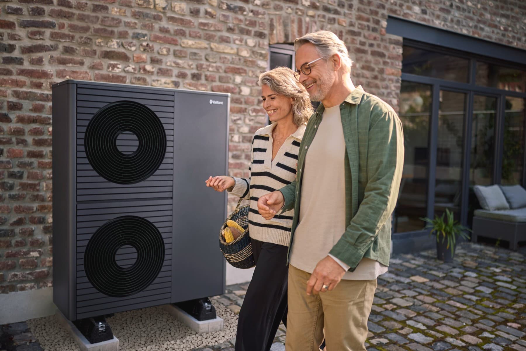 Vaillant ısı pompasının önünde duran orta yaşlı çift