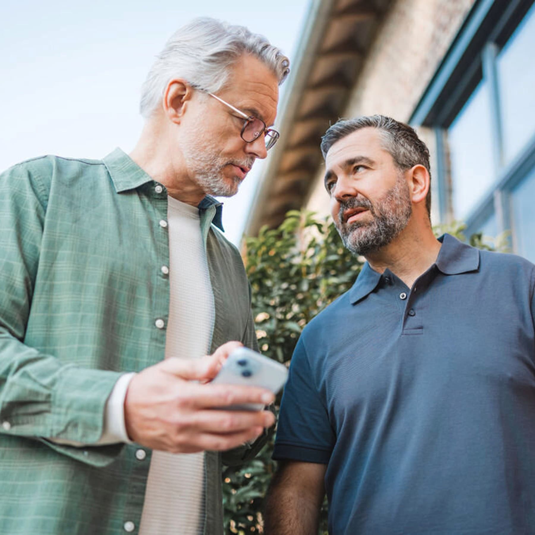 Bir adam, kurulumcuya akıllı telefonunda bir şey gösteriyor